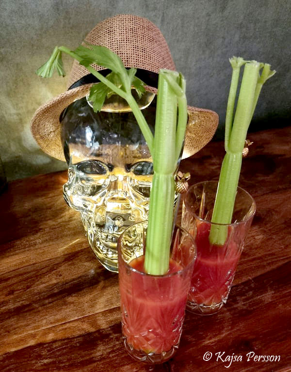 Två Bloody Mary drinkar framför ett upplyst dödskallehuvud fyllt med vodka