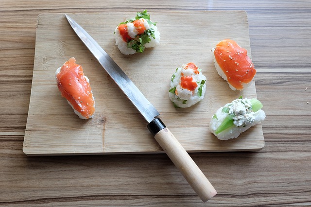 japansk kockkniv på skärbräda med sushi