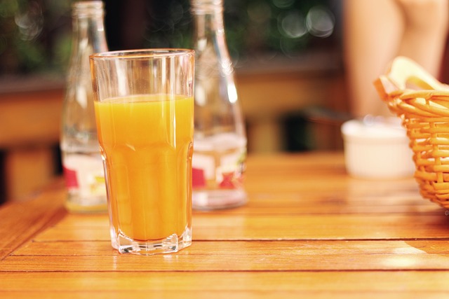 Ett glas med apelsinjuice på ett bord.