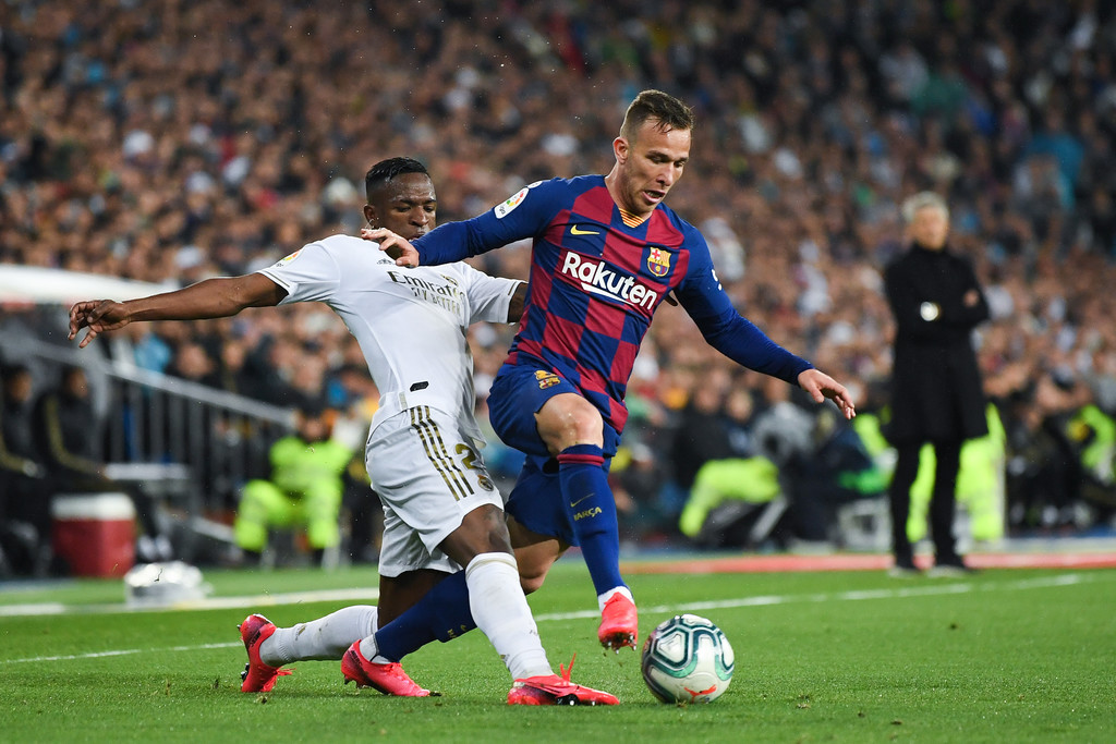 Barcelona's Arthur Melo (R) and Real Madrid's Vinicius Jr. (L) competing for the ball, during El Clásico at the Santiago Bernabéu / GETTY IMAGES EUROPE