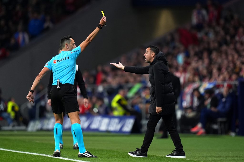 Xavi receiving a yellow card vs. Atletico Madrid / Getty Images