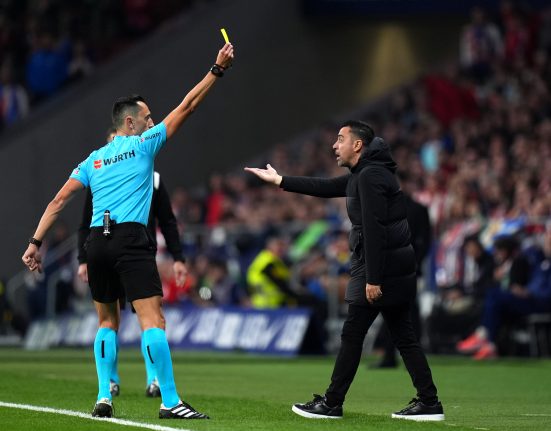 Xavi receiving a yellow card vs. Atletico Madrid / Getty Images