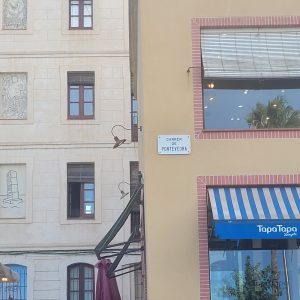 road sign in Barcelona saying Carrer de Pontevedra 
below the sign there is a shop called Tapa Tapa