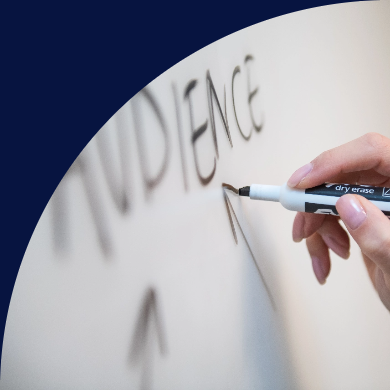 Close-up of a hand writing the word "AUDIENCE" on a whiteboard, signifying strategic planning