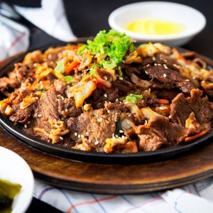 Bild på bulgogi, traditionell koreansk maträtt med tunt skivat marinerad grillad nötkött.