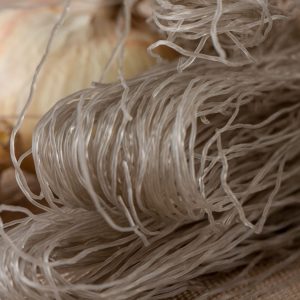 Bild på sötpotatisnudlar, genomskinliga och elastiska, idealiska för att absorbera smaker i rätter som japchae Bild på sötpotatisnudlar, genomskinliga och elastiska, idealiska för att absorbera smaker i rätter som japchae