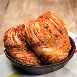 Bild på en skål med kimchi, fermenterad kinakål med en röd och kryddig marinad som ger en stark och syrlig smak
