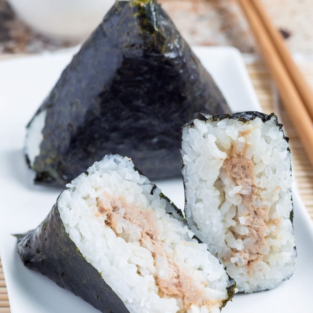 Bild på samgak kimbap, en koreansk ristriangel inlindad i nori med en fyllning av tonfisk, praktiskt för en snabb måltid