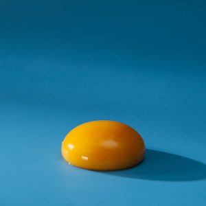 En äggula, gul och glänsande, perfekt för att ge krämighet till rätter och desserter.