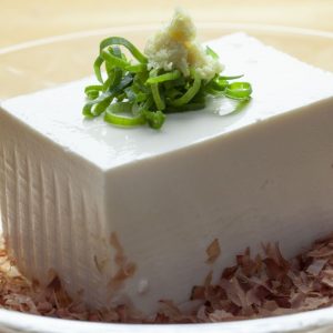 En djup tallrik med silken tofu, mjuk och vit med en len konsistens, perfekt för soppor och sallader