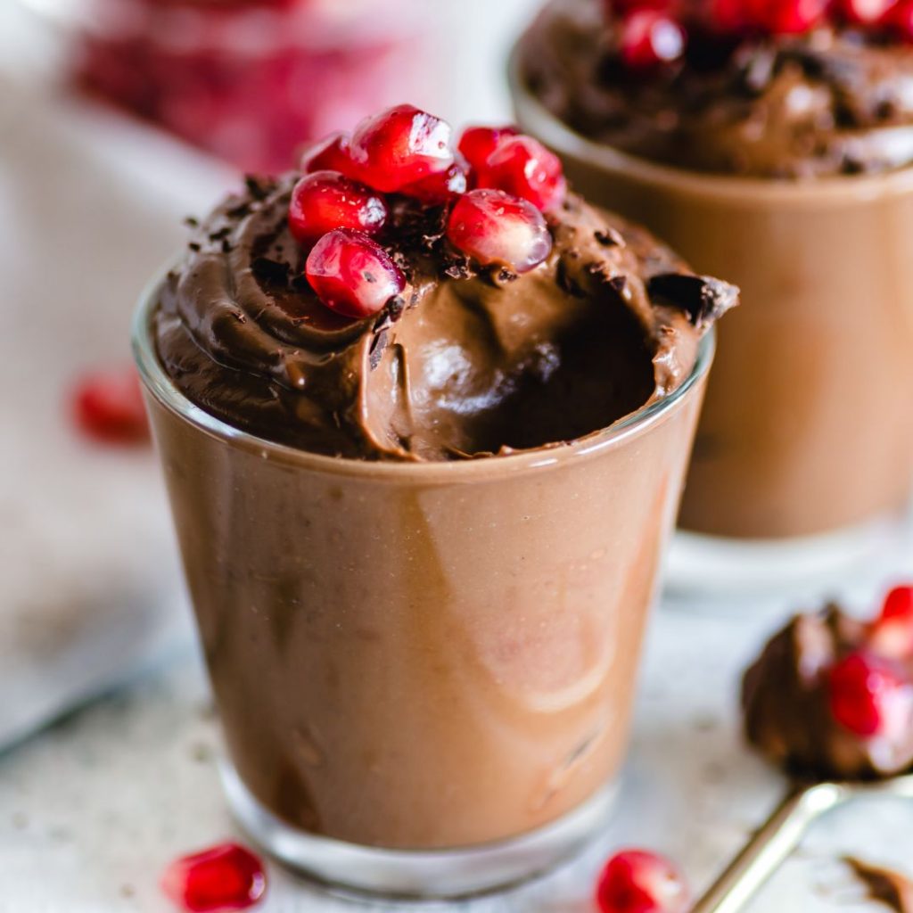 En glas med tofuchokladpudding, slät och krämig med en rik chokladfärg och en mjuk textur.
