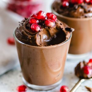 En glas med tofuchokladpudding, slät och krämig med en rik chokladfärg och en mjuk textur.