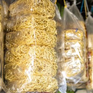 En hängande påse med äggnudlar, gula och elastiska, klara att kokas och användas i soppor och wok. En hängande påse med äggnudlar, gula och elastiska, klara att kokas och användas i soppor och wok.