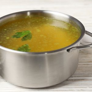 En katrull med klar buljong, varm och aromatisk, fylld med djupa umamismaker för att komplettera ramen.