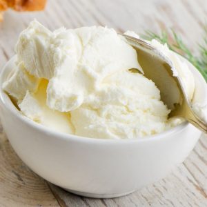 En skål med cream cheese, mjuk och len med en syrlig underton, ofta använd som fyllning i bakverk och cheesecakes