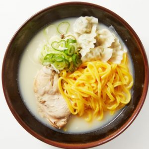 En skål med kalguksu, handgjorda nudlar i en varm och smakrik soppa med kycklinglår och dumplings garnerad med salladslök.