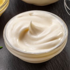 En skål med krämig majonnäs, ljus och len med en mild, fyllig smak, idealisk som topping eller dressing.