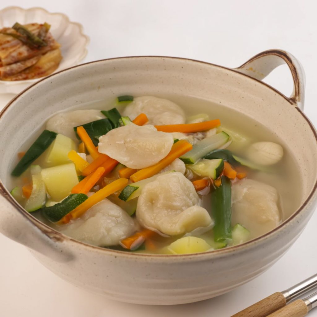 En skål med sujebi, handrivna degbitar i en smakrik buljong med zucchini och morötter, koreansk komfortmat