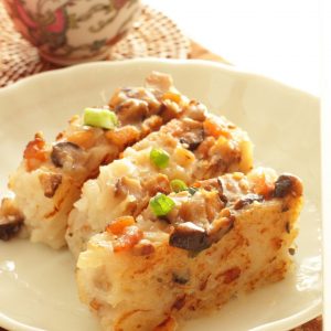 En tallrik med kinesisk Lo bak go, vit ångad rätt av rädisa, med shiitake svamp, torkade räkor och gröna ärtor på toppen.