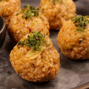 En tallrik med röda jumeokbap, små, kompakta risbollar fyllda med smakrika ingredienser
