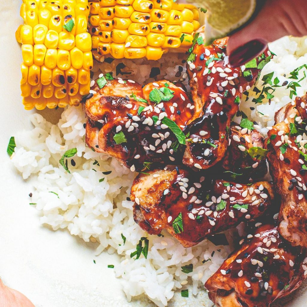 En tallrik med sticky chicken, kycklingbitar täckta i en klibbig, smakrik sås, perfekt för en söt och kryddig smakupplevelse