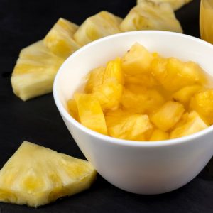 En vit skål med ananasbitar, söta och saftiga med en gul gyllene färg, perfekt till efterätter eller matlagning. En vit skål med ananasbitar, söta och saftiga med en gul gyllene färg, perfekt till efterätter eller matlagning.