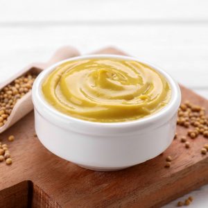 En vit skål med dijonsenap, ljusgul och fyllig med en pikant och mild kryddighet. En vit skål med dijonsenap, ljusgul och fyllig med en pikant och mild kryddighet.