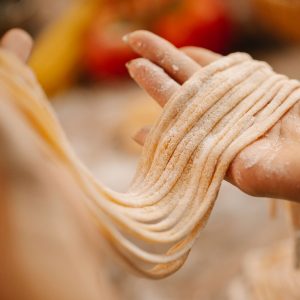 Händer som håller i okokta udonnudlar, vita och sega, redo att kokas för en nudelsoppa. Händer som håller i okokta udonnudlar, vita och sega, redo att kokas för en nudelsoppa.