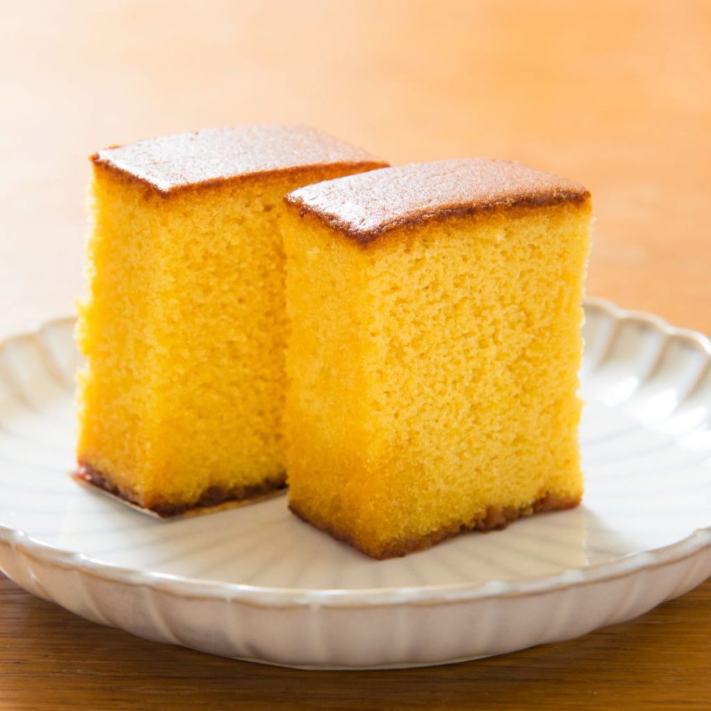 Japansk castella cake, ljusgul och luftig med en mjuk och svampig textur, känd för sin milda sötma.