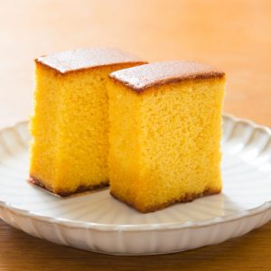 Japansk castella cake, ljusgul och luftig med en mjuk och svampig textur, känd för sin milda sötma.