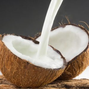 Kokosmjölk som hälls i en kokosnöt, krämig och vit, med en rik smak av kokosnöt, perfekt för desserter som coconut jelly.