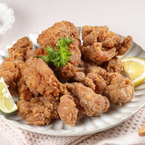 Tallrik med karaage, japansk friterad kyckling, krispig och gyllene yta, saftig insida smaksatt med soja och ingefära.