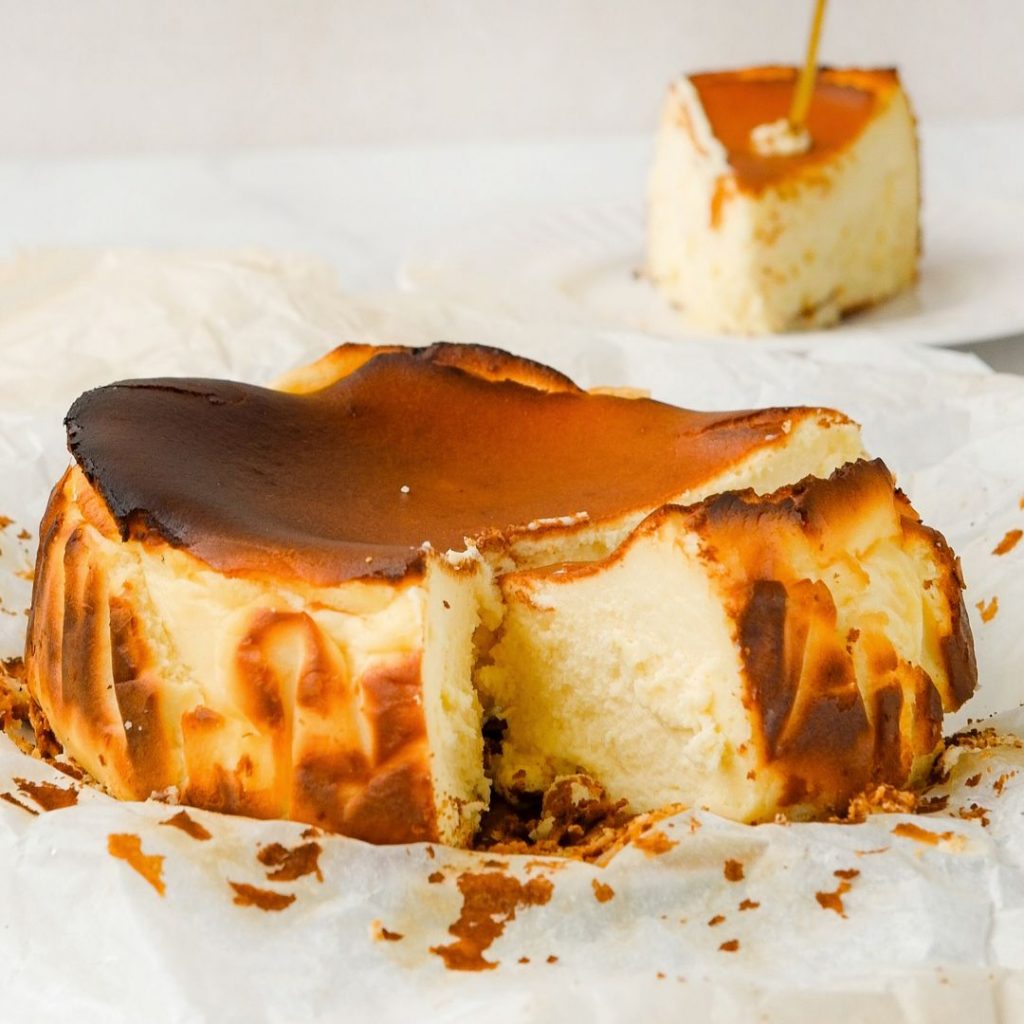 En gräddad japansk burnt basque cheesecake, med en mörkbränd yta och gul krämig mitten, med rik smak