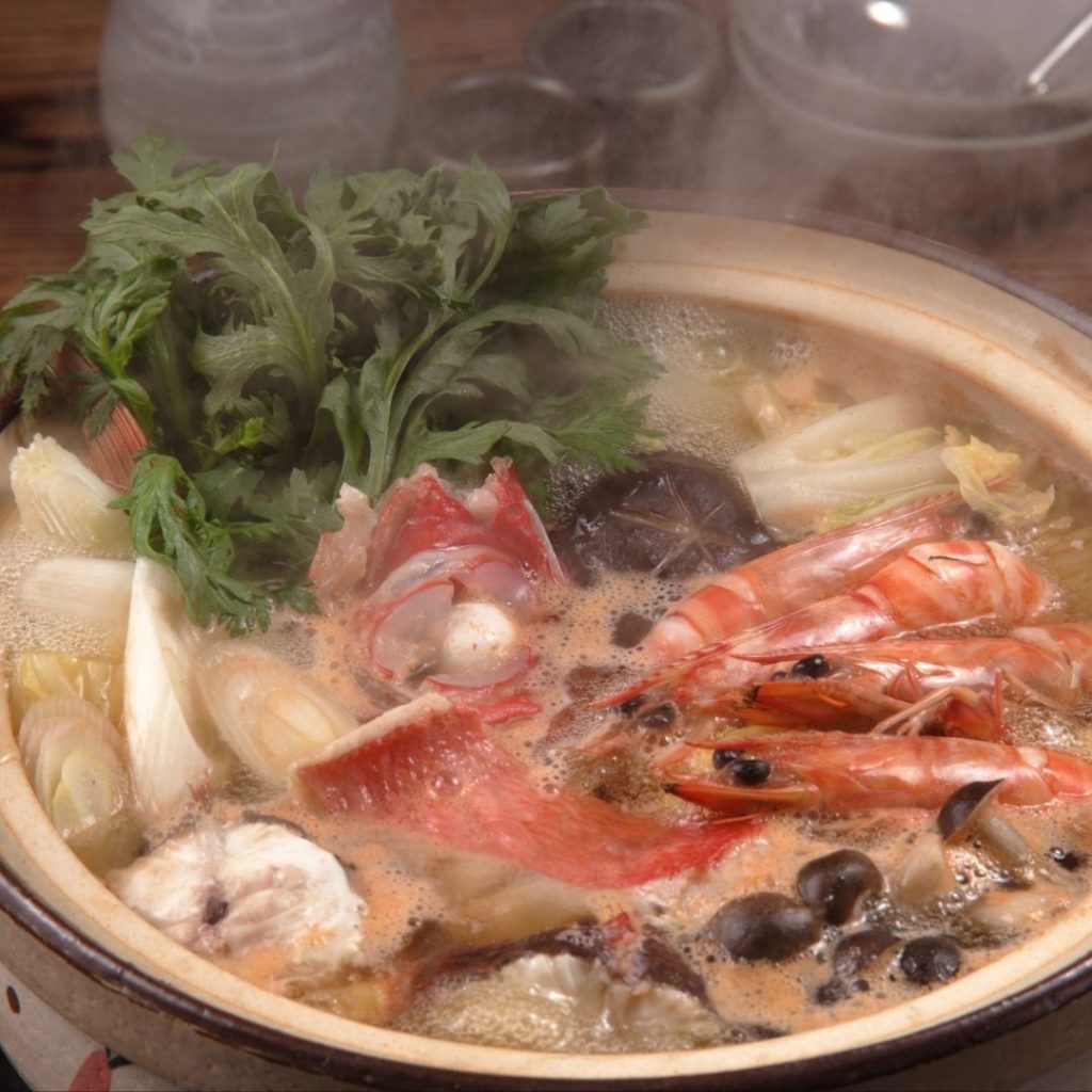 En gryta av Yosenabe, fylld med skaldjur, tofu och grönsaker i en smakrik buljong