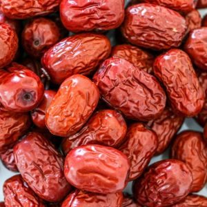 En hög av torkade jujubefrukter, perfekta för te eller soppor, i mörkröd färg, fyllda med naturlig sötma och smak.