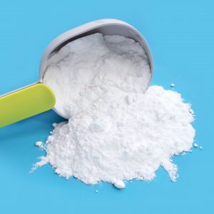 En liten vältande sked med bakpulver, en viktig ingrediens för att ge bakverk och desserter sin fluffiga konsistens.