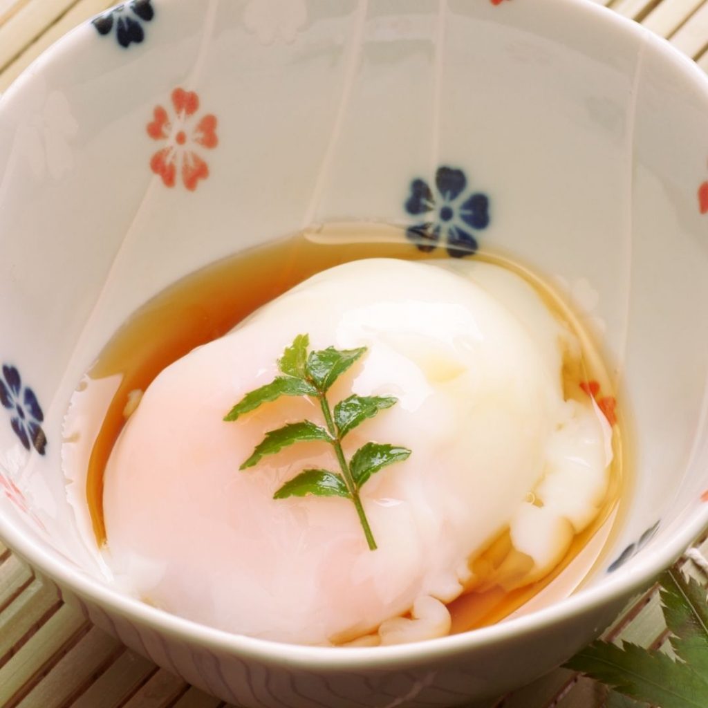 En onsen tamago, ett perfekt kokt ägg med en mjuk gula och silkeslen vita, serverat i en liten skål