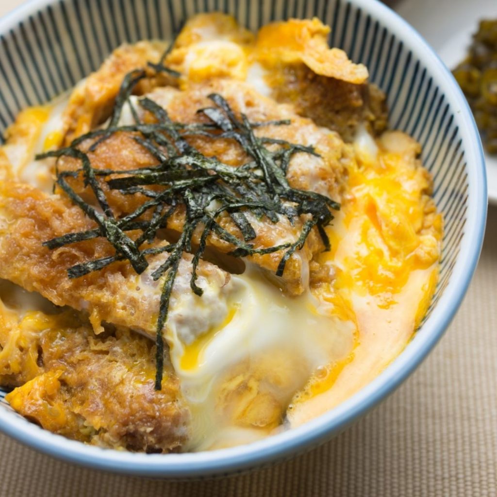 En skål med Chicken katsudon, en skål med ris toppad med kyckling katsu och sojainfuserad omelett.