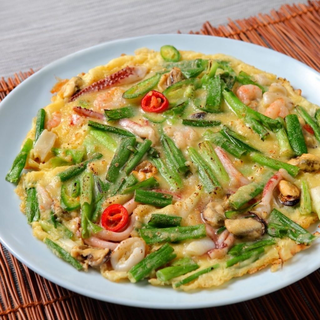 En stor Haemuljeon, koreansk skaldjurspannkakor med salladslök och krispiga kanter.