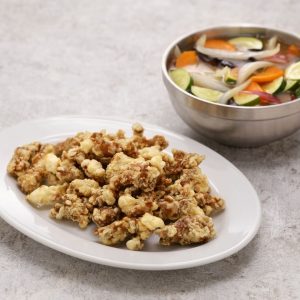 En tallrik med Tangsuyuk bumeok, serverad med såsen vid sidan för att bibehålla krispigheten En tallrik med Tangsuyuk bumeok, serverad med såsen vid sidan för att bibehålla krispigheten.