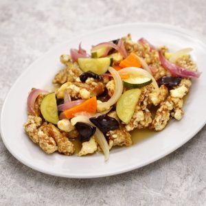 En tallrik med Tangsuyuk jjikmeok, där såsen är hällt över köttet för en saftig smakupplevelse En tallrik med Tangsuyuk jjikmeok, där såsen är hällt över köttet för en saftig smakupplevelse