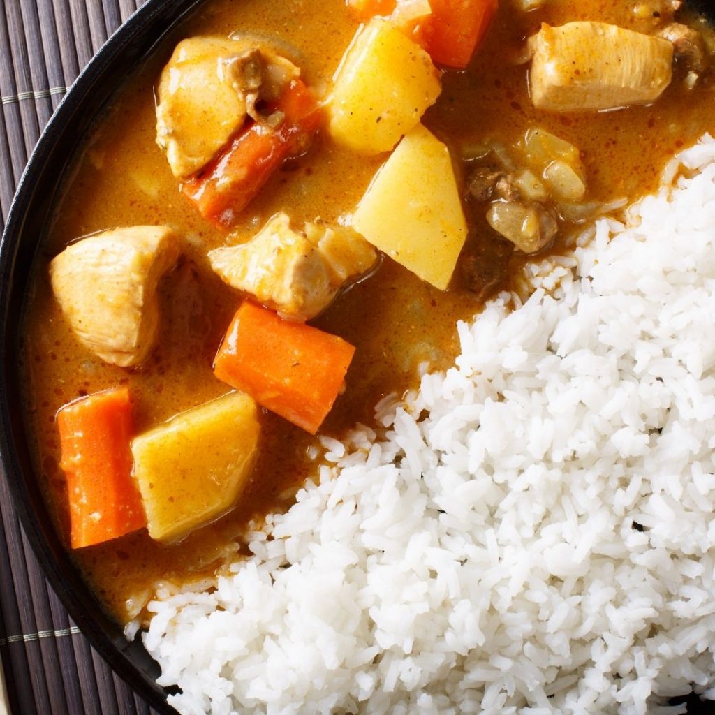 En tallrik med ångat ris och krämig japansk curry med kyckling, potatis och grönsaker