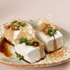 En tallrik med hiyayakko, kyld och kall tofu toppad med riven ingefära, grön lök och härlig sojasås