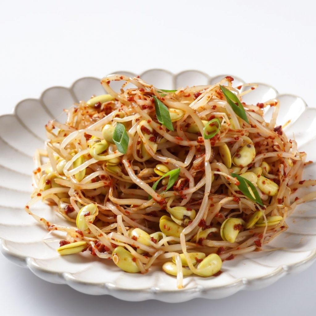 En tallrik med kryddig kongnamul muchim, koreansk marinerade böngroddar, smakrik och krispiga groddar