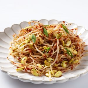 En tallrik med kryddig kongnamul muchim, koreansk marinerade böngroddar, smakrik och krispiga groddar