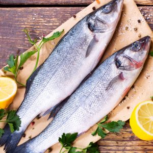 Två färska hela fiskar, i glittrande silver av fjällen, redo för grillning eller ångkokning.