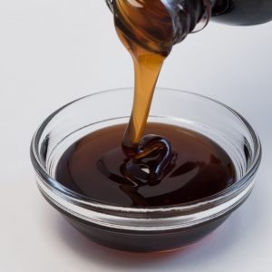 En bild på rinnande tjock, gyllene maltos, en sirap som används i kinesiska desserter och snacks.