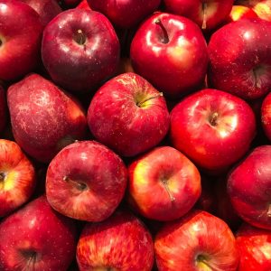 En bild på röda äpplen, med sina glänsande skal och fräscha utseende, som ligger ordnade på en yta.