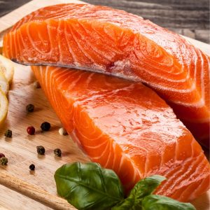 En rå laxfilé med ljusrosa och marmorerat kött, redo för tillagning eller sashimi.