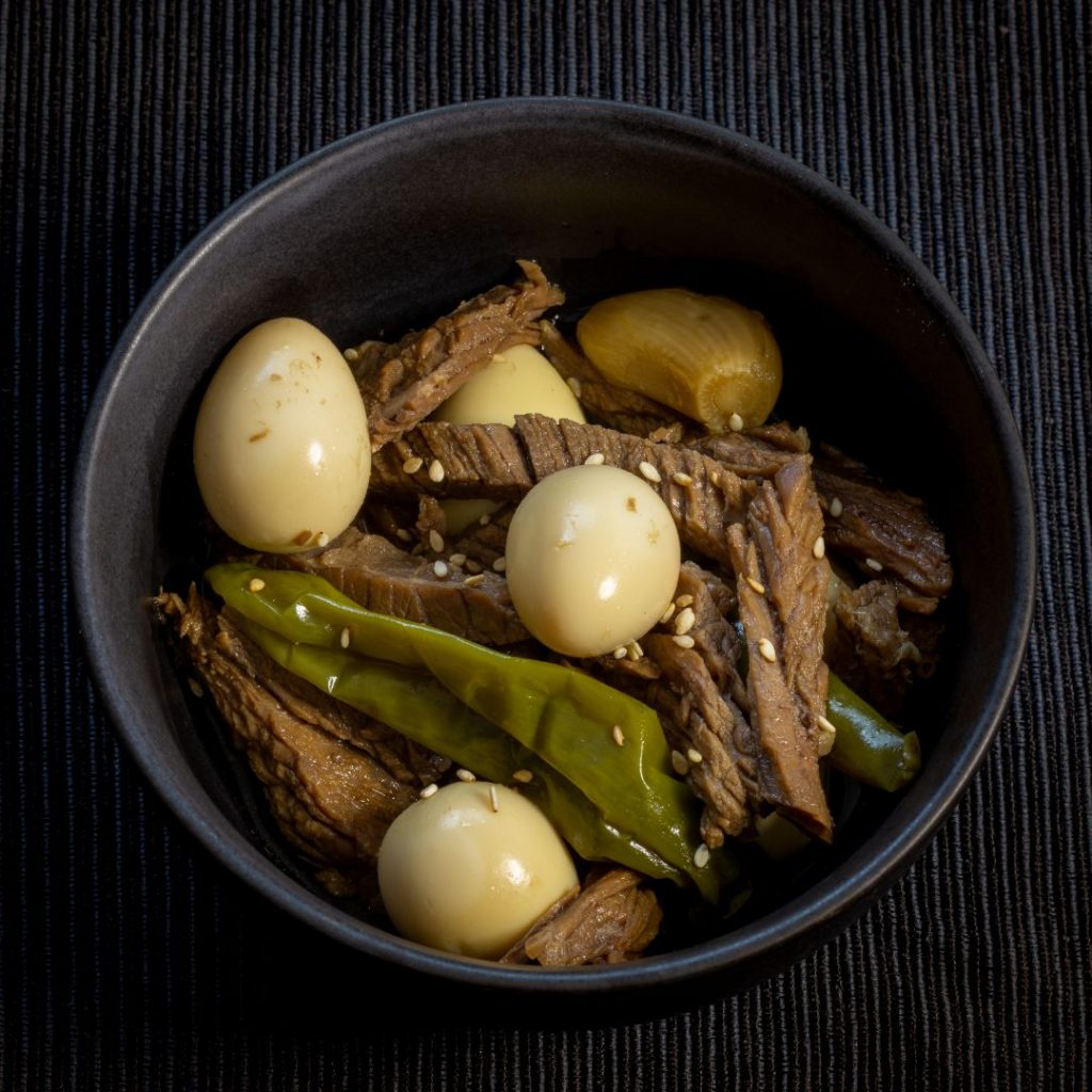 En skål med Jangjorim, sojainlagd nötkött med en rik och salt smak, med vaktelägg